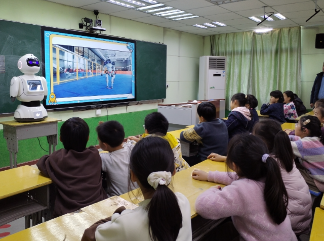 学生们手持一个“口袋乌龟然后将其放在涂有不同色彩的纸上 学生们手持一个“口袋乌龟然后将其放在涂有不同色彩的纸上